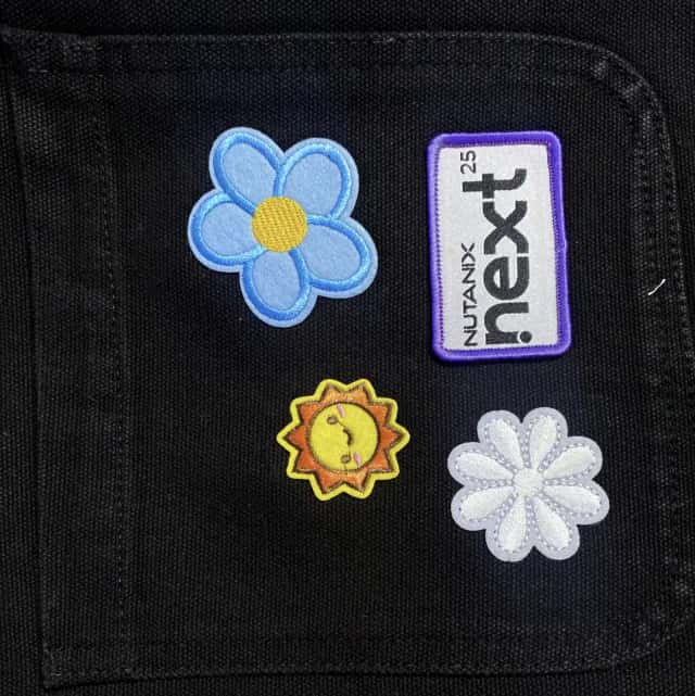 Embroidered patches pressed onto a jacket pocket at a patch bar