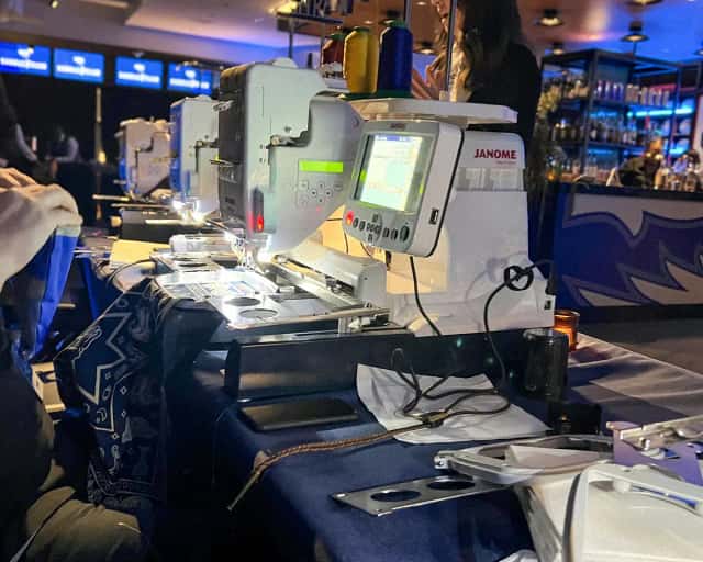 Embroidery machines stitching custom bandanas during an activation