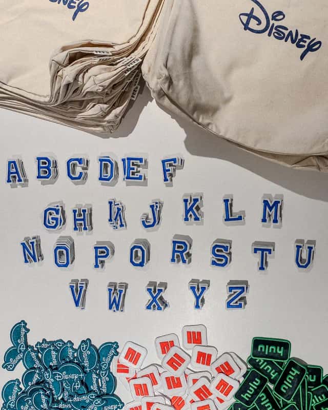 Chenille letter patches and logo patches laid out for a patch bar